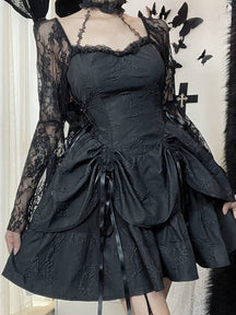 Front view of the black butterfly-textured dress with the lace sleeves worn on the shoulders. Narrow straps connect the bodice to a lace choker above the gathered mini skirt.