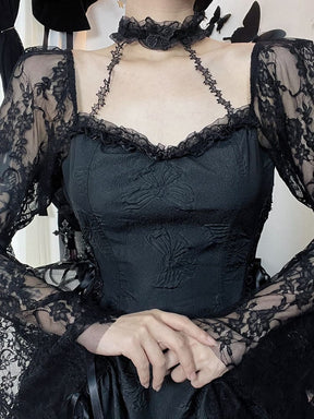 Close front view of the black dress bodice, scalloped lace neckline and attached choker. The model holds both hands together, showing the floral lace sleeves and narrow connecting straps.