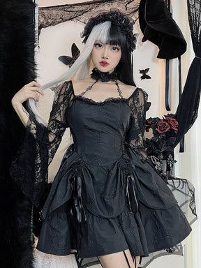 Model wearing the black butterfly mini dress with split black-and-gray hair and a dark veil, holding a strand of hair. Lace bell sleeves frame the fitted bodice and gathered skirt.