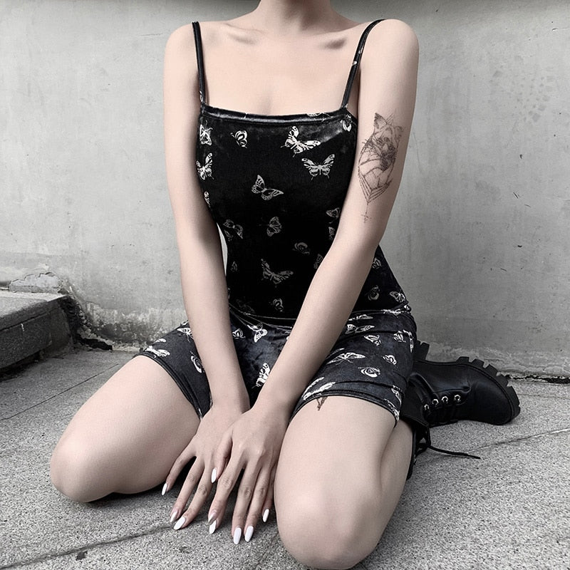 Black velvet butterfly-print mini dress shown in a seated outfit.