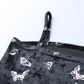Black velvet butterfly-print mini dress with a close view of a slim strap and straight neckline.
