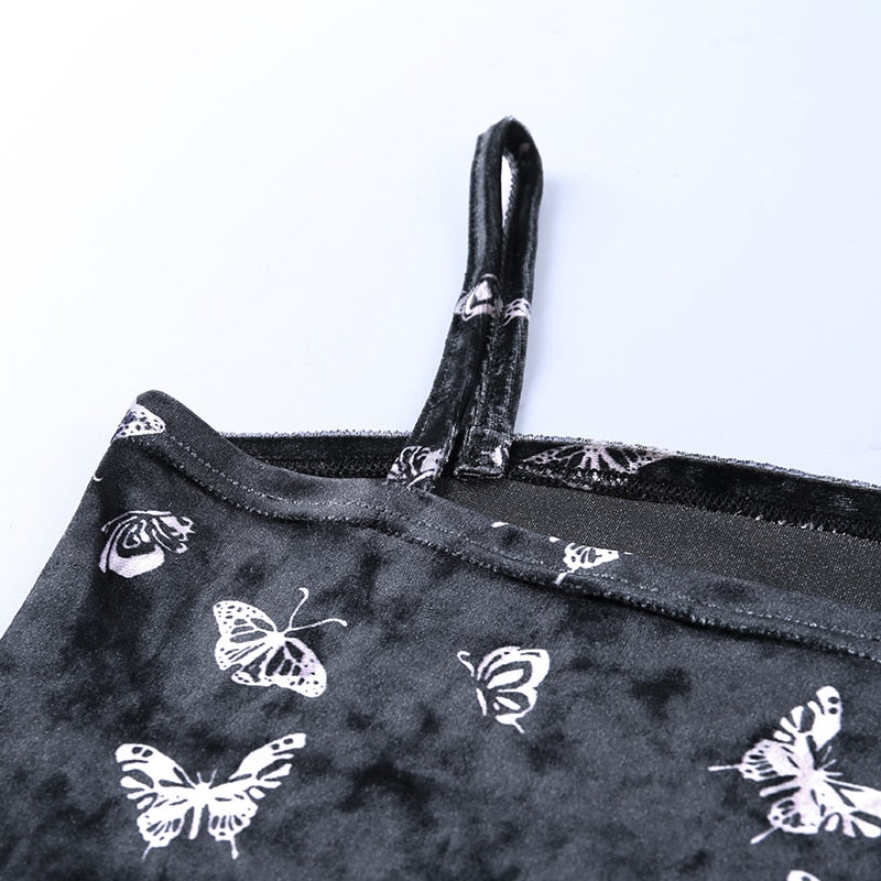Black velvet butterfly-print mini dress with a close view of a slim strap and straight neckline.
