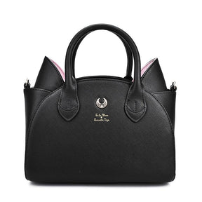 Straight-on view of the black crescent-moon handbag, highlighting the rounded body, two arched handles and pointed cat ears against white.