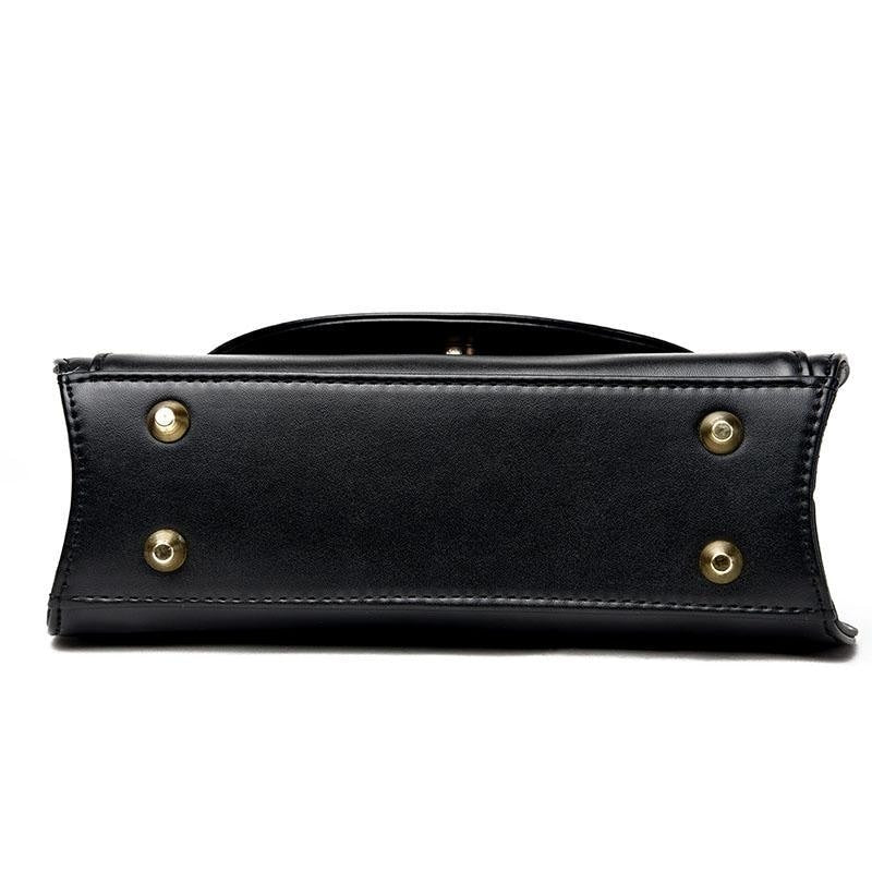 Bottom of the black cat-ear purse, showing the rectangular base with four round gold-tone feet.