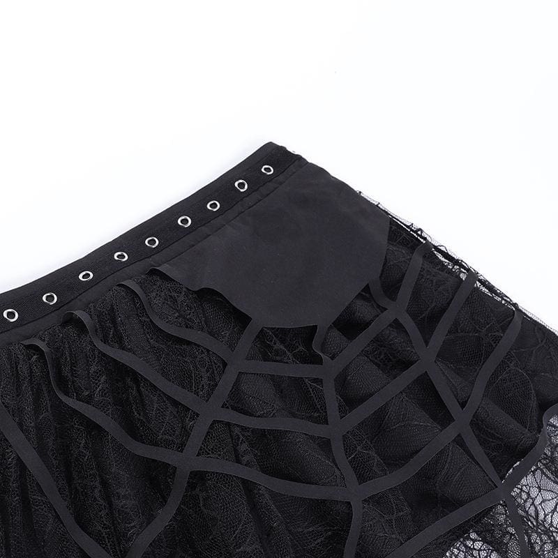 Diagonal flat-lay detail of the eyelet waistband and raised cutout webs on the black skirt.