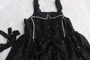 Close-up of the constellation dress bodice with lace-edged straps, pale trim, golden star details and a black waist bow.