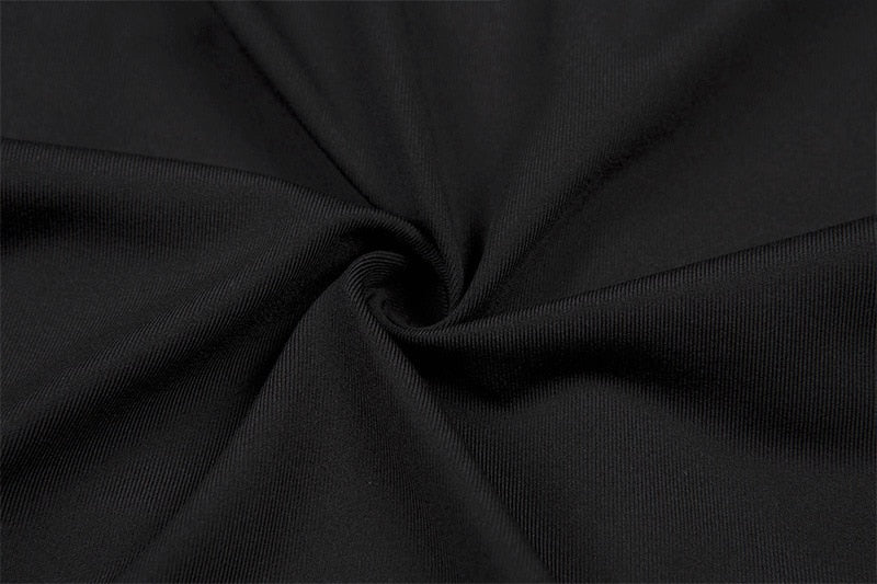 Close-up of the black cotton-blend crop top fabric gathered into folds, showing its fine knit surface.