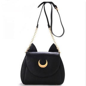 Black crescent-moon cat-ear bag hanging from its extended strap, showing the buckle adjustment and gold-tone chain sections.