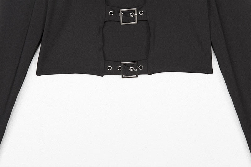 Close view of the lower front of the black crop top, with two eyelet buckle straps bridging the opening above the hem.
