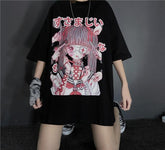 Black anime graphic T-shirt shown in a wide-legged standing pose, with the long hem covering the upper thighs and the pink-and-red artwork fully visible.