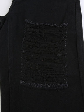 Flat close view of a rectangular distressed section in black denim, with frayed edges and long threads crossing the opening.