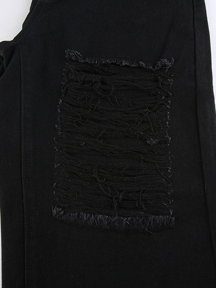 Flat close view of a rectangular distressed section in black denim, with frayed edges and long threads crossing the opening.