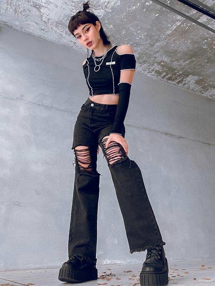 Angled standing pose in the black Y2K flare jeans, showing the laddered thigh rips and flared legs over chunky boots.