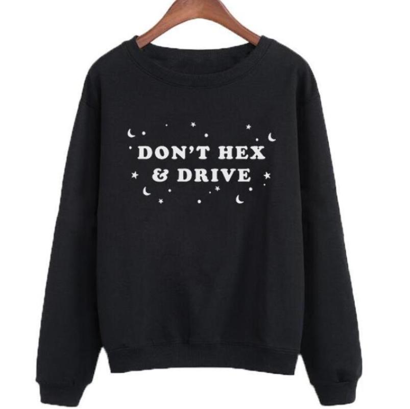 Black witchy crewneck sweatshirt hanging against a pale background, with pale DON’T HEX & DRIVE lettering and scattered moons and stars across the chest.