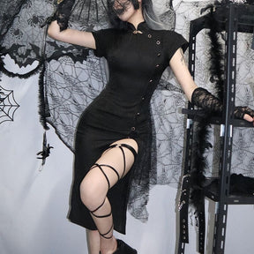 Black dragon-pattern cheongsam styled beside an ornate mirror and cobweb backdrop, with one arm raised to show the short sleeve and fitted bodice.