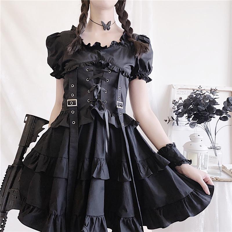 Front view of the black puff-sleeve dress showing the corset lacing, two buckles and long ribbons above a tiered skirt.