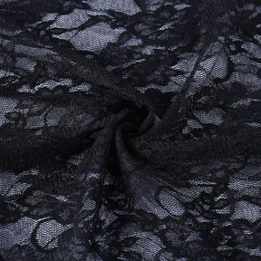 Close-up of gathered black floral lace, showing the sheer mesh ground and raised flower pattern of the overlay.