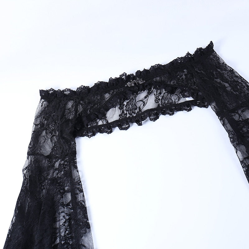 Black lace overlay laid on white, with the ruffled shoulder band and the top of one sleeve shown in detail.