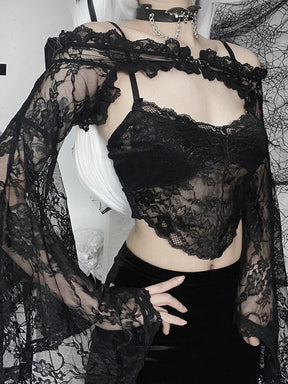 Angled close view of the black floral lace overlay with a hand resting on the hip, showing the ruffled shoulder band and bell sleeve.
