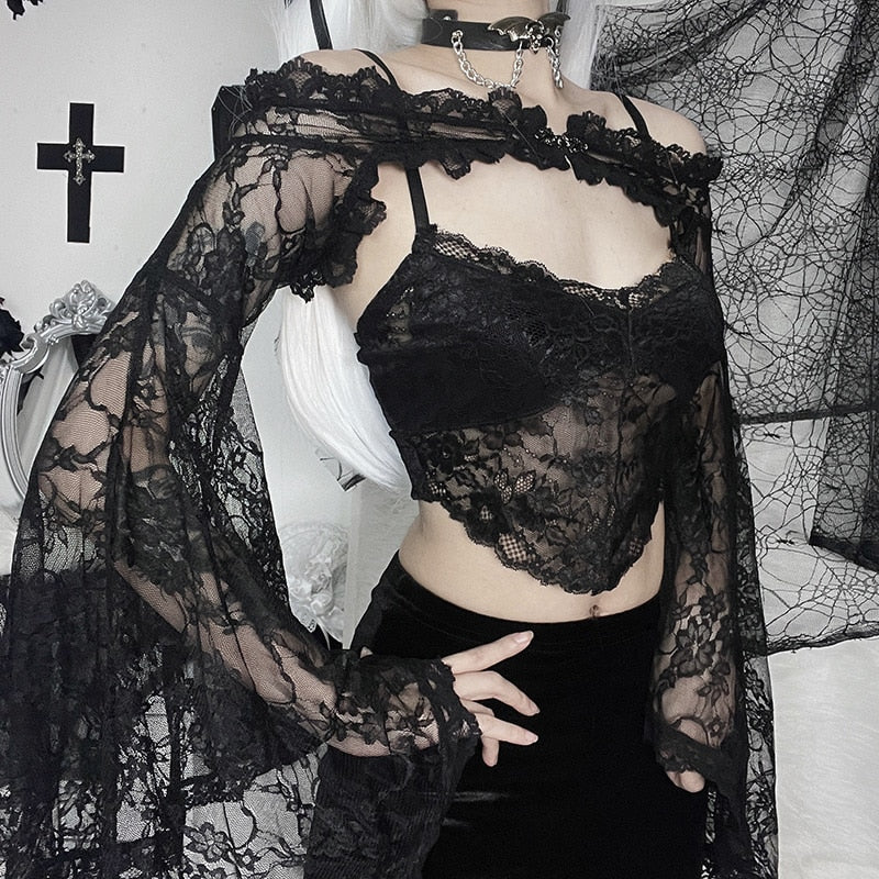 Black gothic lace overlay photographed at an angle, highlighting the flared sleeve beside a separate cami and dark shorts.
