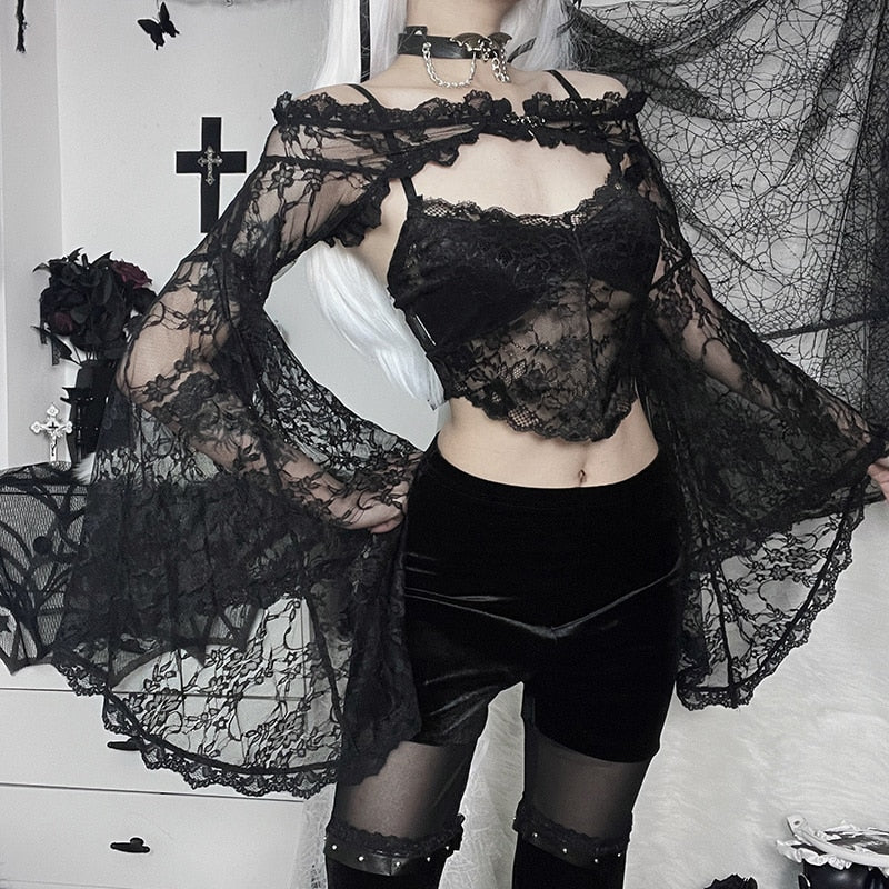 Wider view of the black lace shoulder overlay worn with velvet shorts and sheer tights, with both bell sleeves held away from the body.