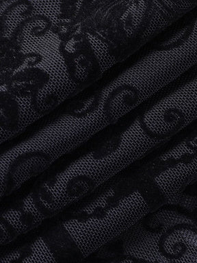 Black ornate patterned mesh gathered into soft folds, showing the contrast between dense scroll shapes and the sheer ground of the bell bottoms.