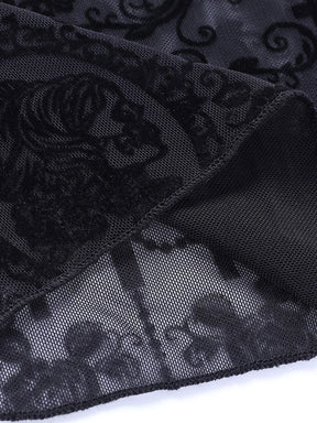 Macro view of a skeletal profile cameo framed by black scrollwork on the sheer bell bottom fabric. Fine mesh is visible between the dark details.