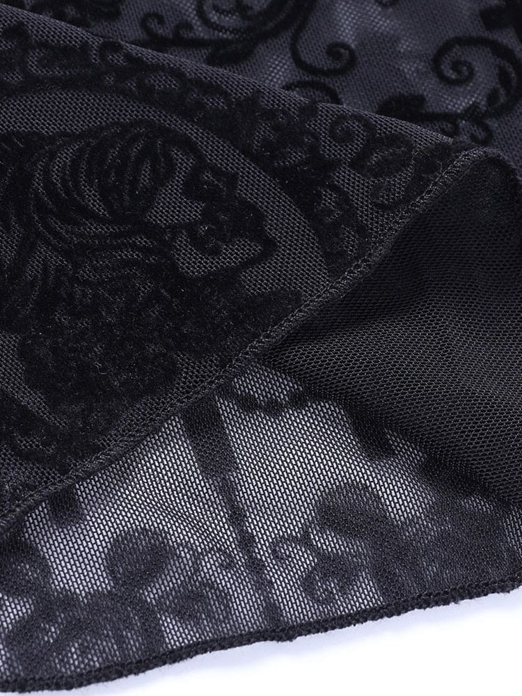 Macro view of a skeletal profile cameo framed by black scrollwork on the sheer bell bottom fabric. Fine mesh is visible between the dark details.