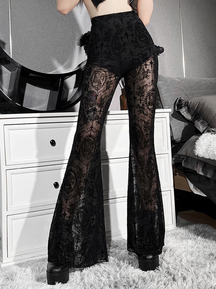 Angled hip view of black sheer bell bottom pants with one hand resting at the waist. The dense pattern contrasts with the translucent mesh.