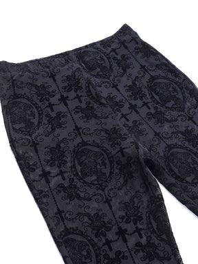 Black bell bottom pants laid flat at the waistband and upper legs. Dark scrollwork overlays the fine mesh around the lined upper section.