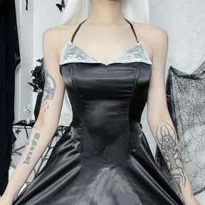 Close-up outfit view of the black dress's curved bodice seams, white floral lace lapels and slender halter straps.