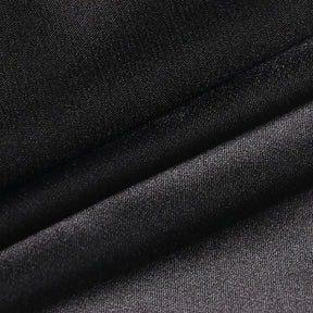 Close-up of the black dress fabric folded to show its fine texture and subtle sheen.