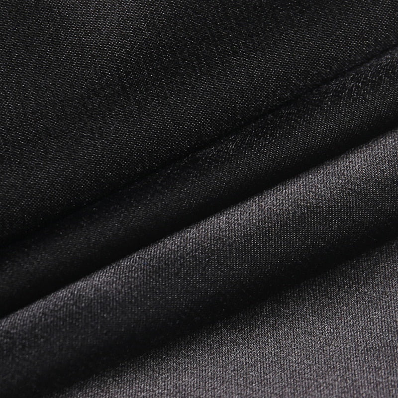 Close-up of the black dress fabric folded to show its fine texture and subtle sheen.