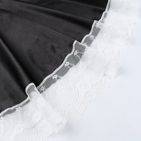 Black skirt fabric meeting the wide scalloped white lace hem, shown flat on a pale background.