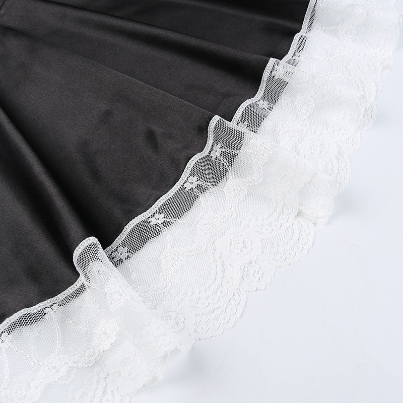 Black skirt fabric meeting the wide scalloped white lace hem, shown flat on a pale background.