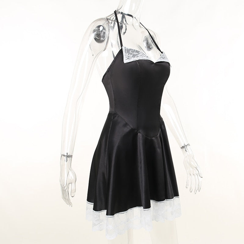 Angled clear-mannequin view of the black satin-finish halter dress with white lace at the neckline and hem.