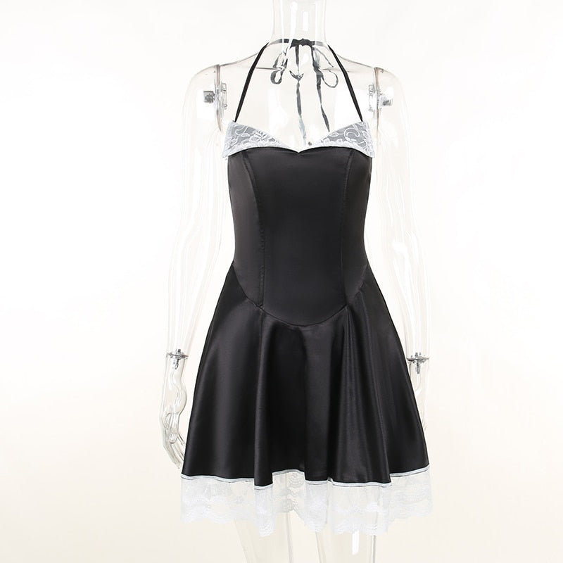 Front view of the black dress on a clear mannequin, showing the halter ties and fitted bodice above the flared skirt.