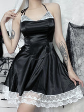 Black gothic halter mini dress with white lace lapels and a scalloped lace hem, worn with one hand holding the flared skirt outward.