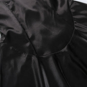 Curved seam at the bottom of the black dress bodice, where the fitted upper section meets the flared skirt.