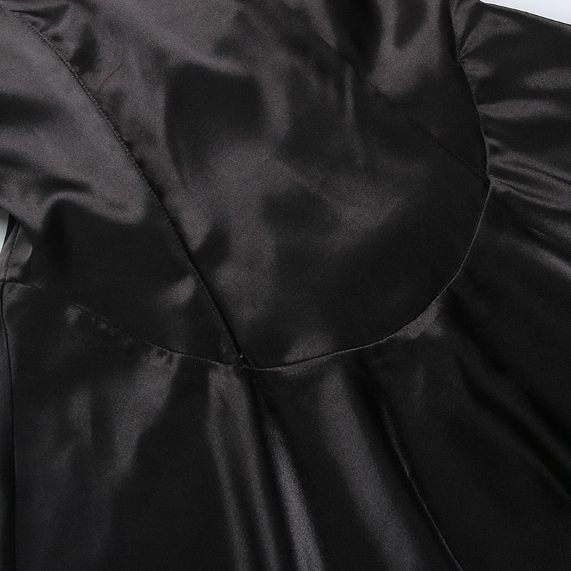 Curved seam at the bottom of the black dress bodice, where the fitted upper section meets the flared skirt.