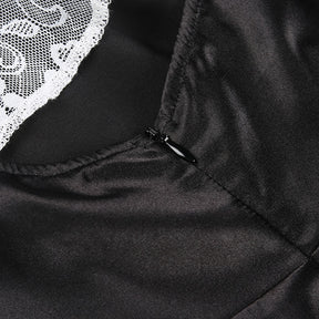 Close detail of the black dress's concealed back zip beside a white lace lapel visible in the background.