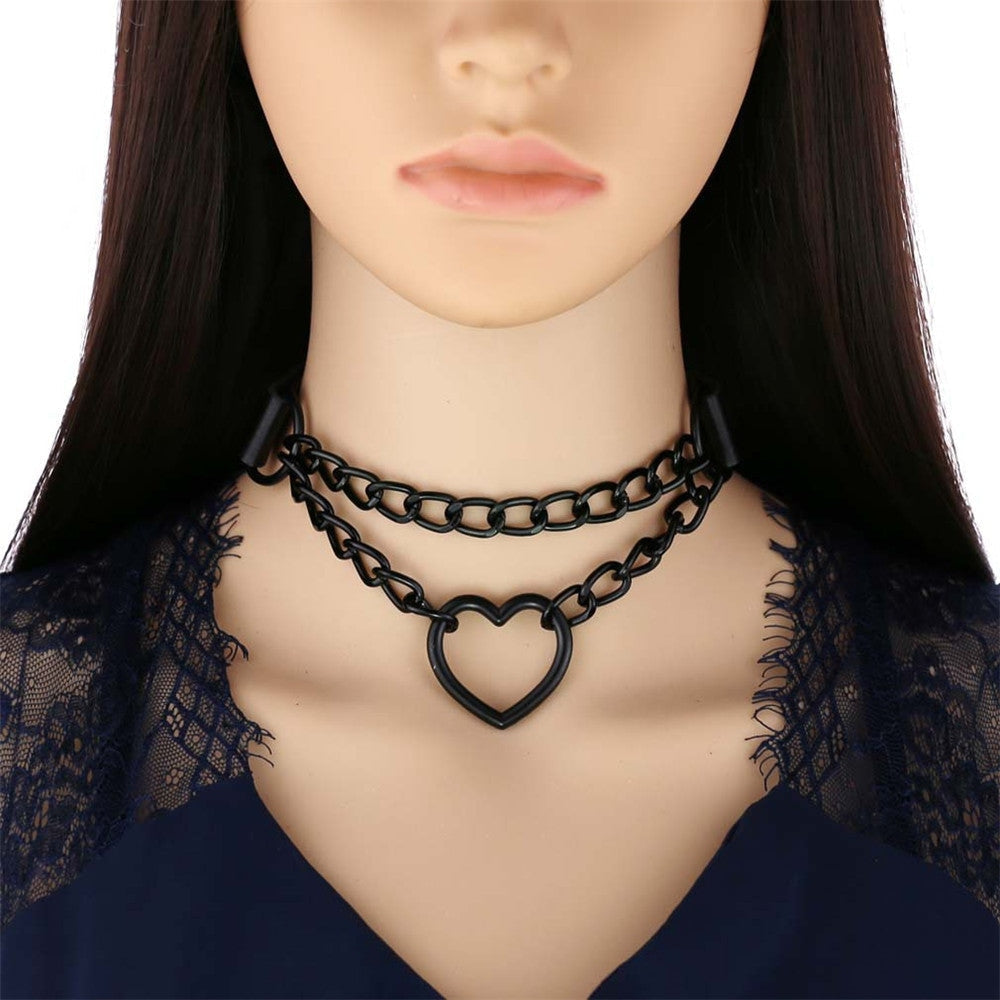 Black double-chain heart choker on a mannequin wearing a dark lace neckline, showing how the two chain rows sit at the front of the neck.