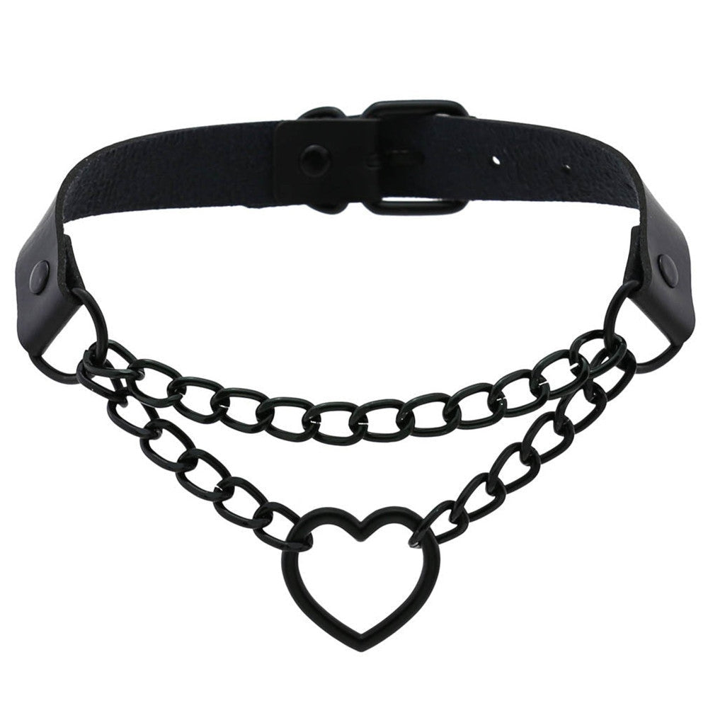 Black faux leather choker with a double-chain front and open heart pendant, arranged to show the band and buckle behind the chains.