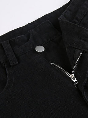 Close-up of the jeans’ asymmetric waistband with a silver-tone button, belt loops and the zip fly partly open.