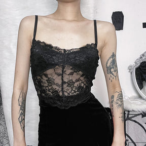 Front outfit view of a separate black lace camisole with thin straps and a scalloped hem, worn with a black skirt. This camisole is not included with the velvet overlay.