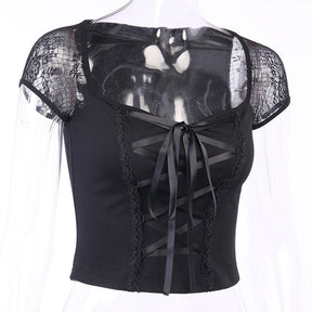 Closer mannequin view of the fitted black lace-up top, with a bow and long ribbon ends above the straight lower hem.