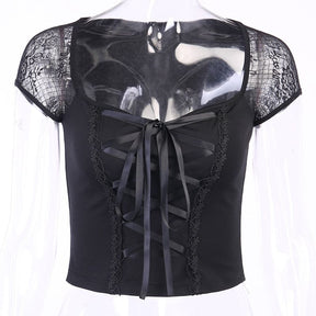 Black crop top on a clear mannequin, displaying its wide neckline, floral mesh cap sleeves and central ribbon lacing.