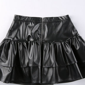 Back of the black ruffle mini skirt laid flat, showing the central zipper and the upper and lower tiers.