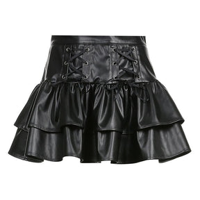 Black faux leather mini skirt isolated against white, with a wide lace-up waistband and two stacked ruffle tiers.