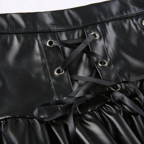 Close-up of black ribbon threaded through silver-tone eyelets in the two front panels of the faux leather skirt.